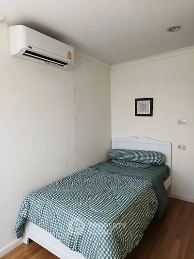 Cozy bedroom with air conditioning and stylish decor, perfect for a comfortable living experience.