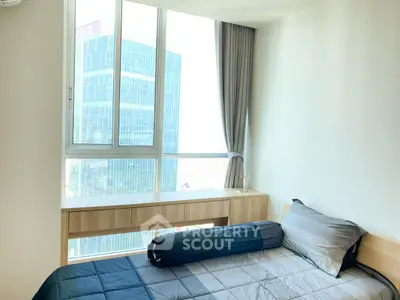 Modern bedroom with large window and city view, featuring stylish bedding and minimalist decor.