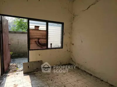 Abandoned room with broken window and peeling walls, potential renovation project.