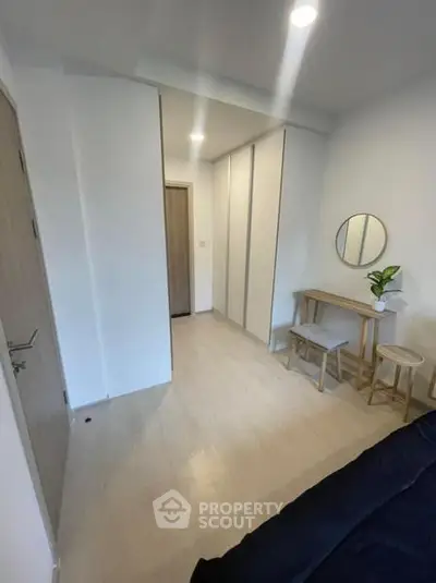 Modern minimalist bedroom with sleek furniture and ample storage space.