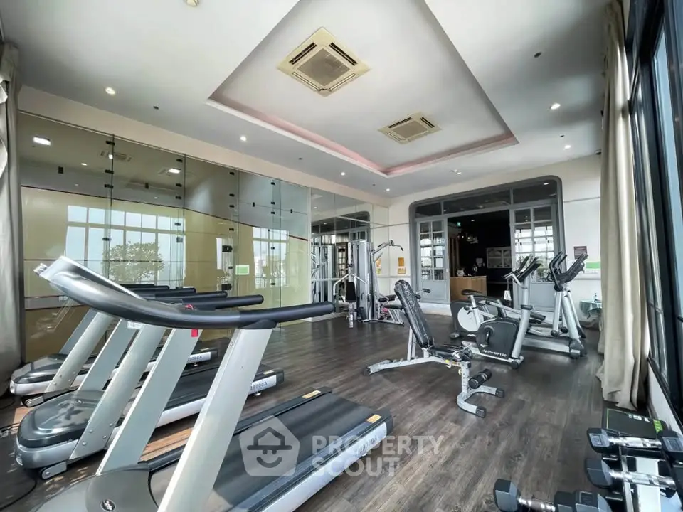Modern gym with state-of-the-art equipment and large windows for natural light.
