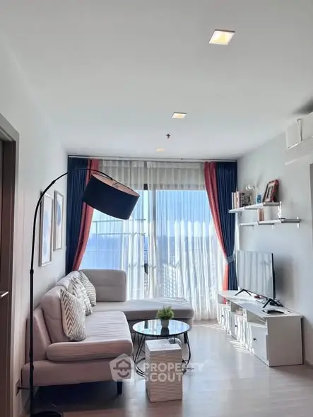 Modern living room with stylish decor, large windows, and cozy seating area.