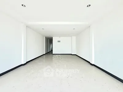 Spacious empty room with white walls and tiled floor, ideal for customization.