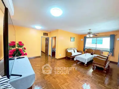 Spacious living room with wooden flooring and elegant furniture, perfect for family gatherings.