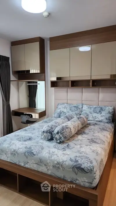 Cozy bedroom with modern furnishings and floral bedding in a stylish apartment.