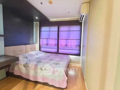 Cozy bedroom with wooden flooring and large windows featuring elegant blinds.