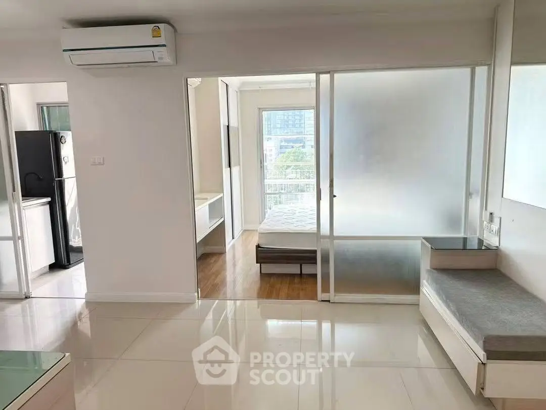 Modern apartment interior with sleek design and natural light, featuring a cozy bedroom and open living space.