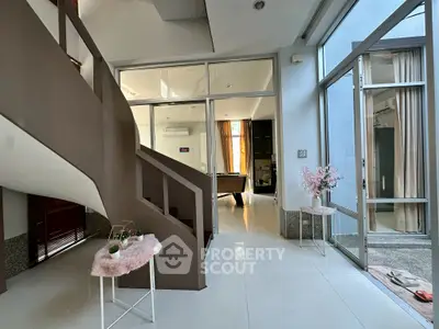 Spacious modern interior with elegant staircase and pool table, perfect for entertainment and relaxation.