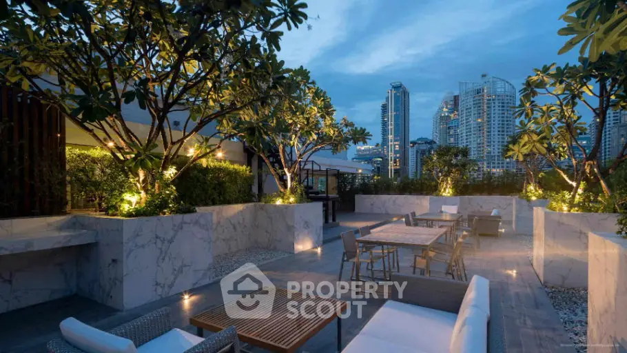Luxurious rooftop terrace with elegant seating and stunning city skyline views at dusk.