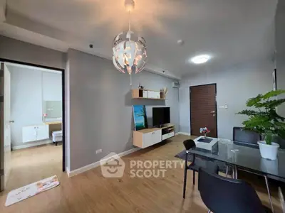 Modern living room with stylish decor and open layout, featuring a dining area and TV setup.