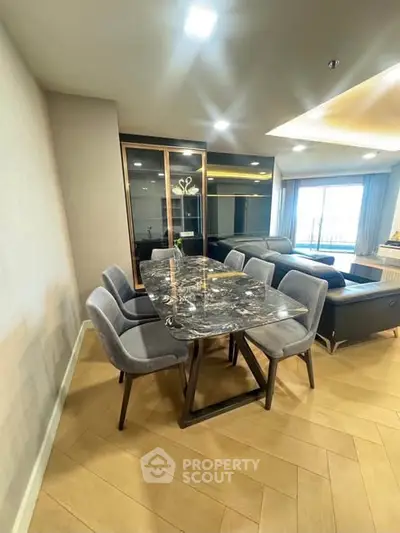 Luxurious modern living room with elegant dining area and large windows offering natural light.