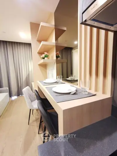 Modern kitchen with sleek breakfast bar and stylish shelving in a cozy apartment.