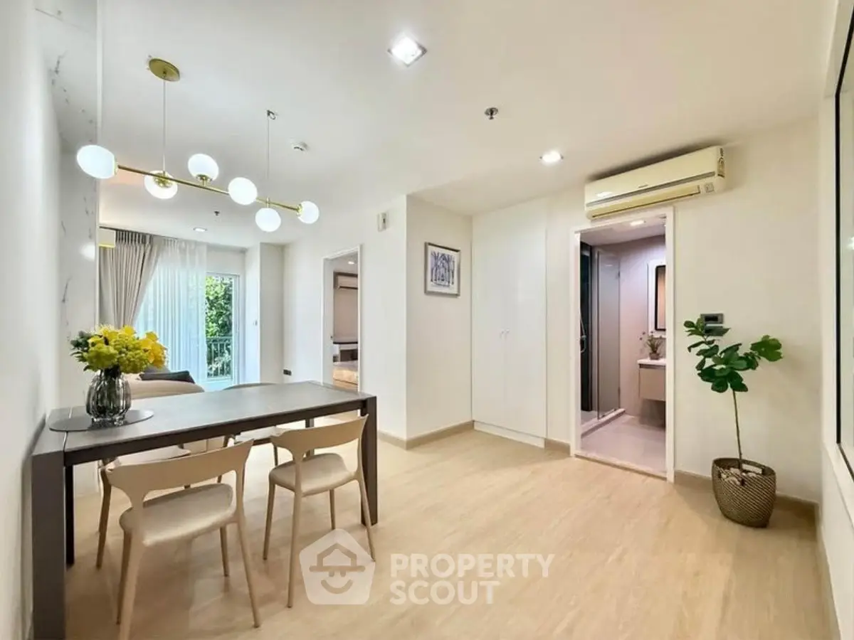 Modern open-plan living and dining area with stylish lighting and natural light.
