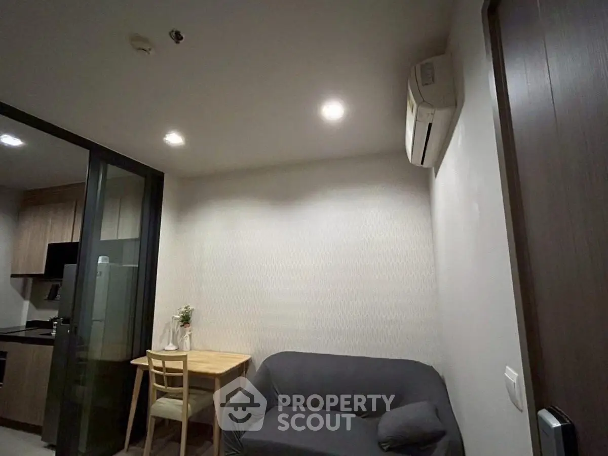 Cozy living room with modern air conditioning and compact dining area in a stylish apartment.