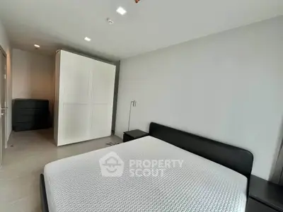 Spacious modern bedroom with sleek furniture and ample storage space.