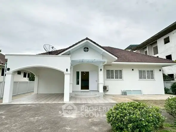 Charming single-story house with a spacious driveway and classic gable roof, perfect for family living.