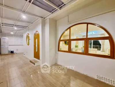 Spacious modern interior with arched windows and wooden accents, perfect for stylish living.