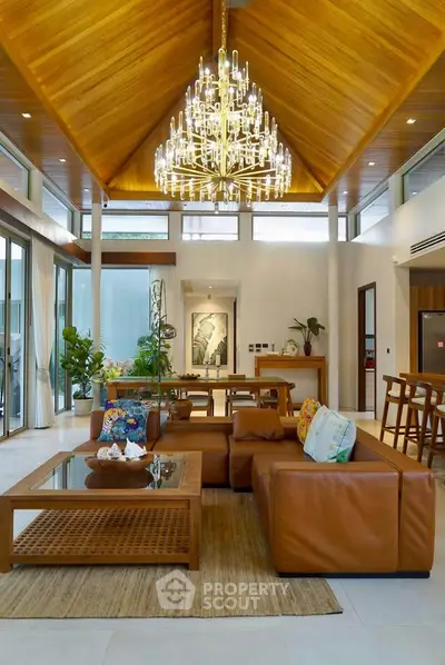 Luxurious living room with high wooden ceiling and elegant chandelier