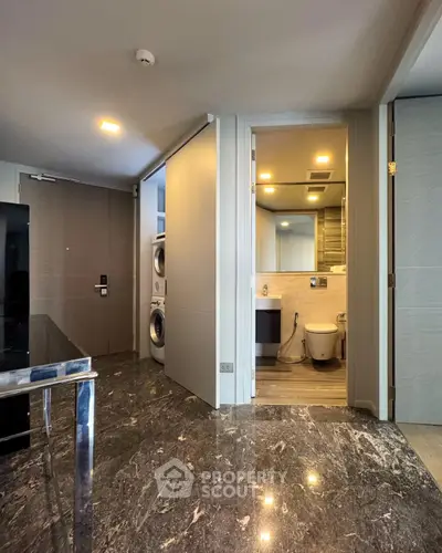 Modern apartment with marble flooring, laundry area, and sleek bathroom design.
