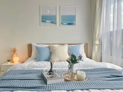 Cozy bedroom with elegant decor and natural light, featuring a stylish bed and serene artwork.