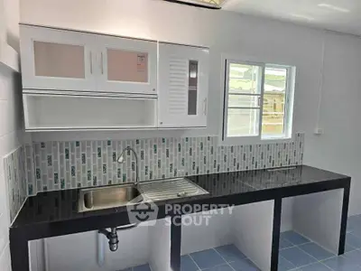 Modern kitchen with sleek black countertop and stylish backsplash