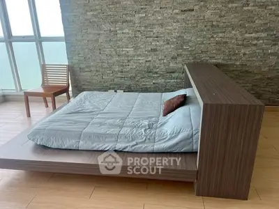 Modern bedroom with stone accent wall and minimalist wooden furniture