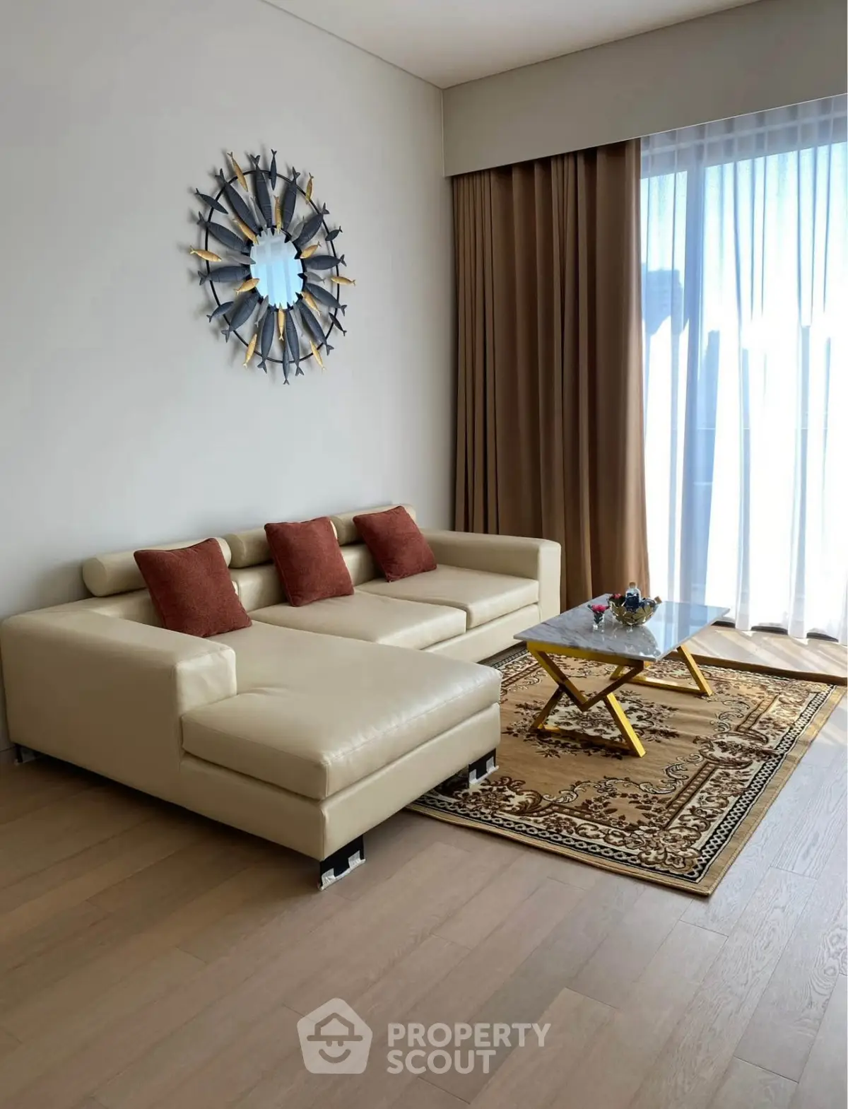 Elegant living room with beige sofa, decorative wall mirror, and floor-to-ceiling window.
