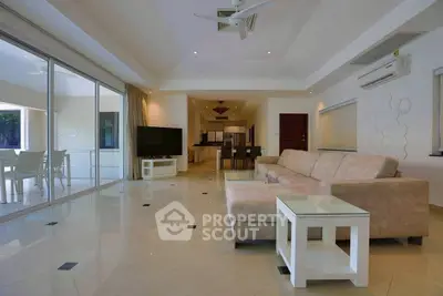 Spacious modern living room with large windows and elegant furnishings.