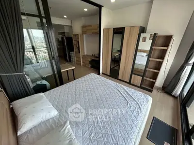 Modern bedroom with large windows and city view, featuring sleek furniture and ample storage space.