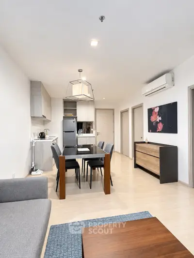 Modern open-plan living room and kitchen with stylish dining area and contemporary decor.