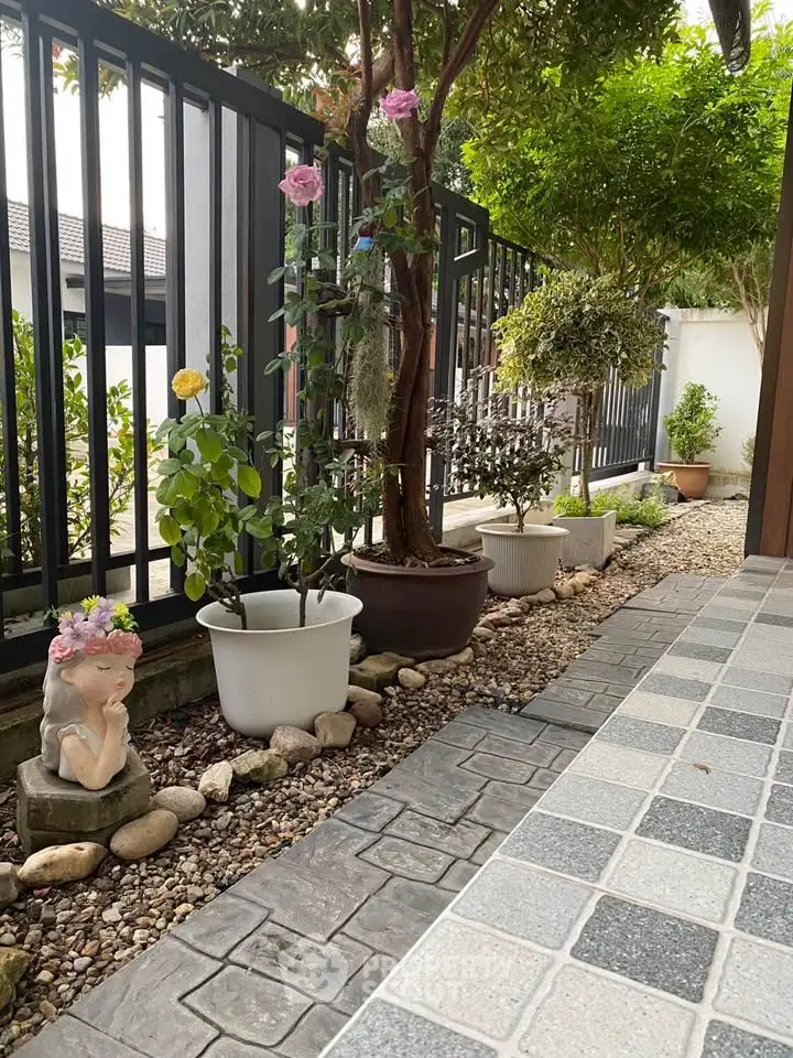 Charming garden with potted plants and decorative statue, perfect for serene outdoor living.