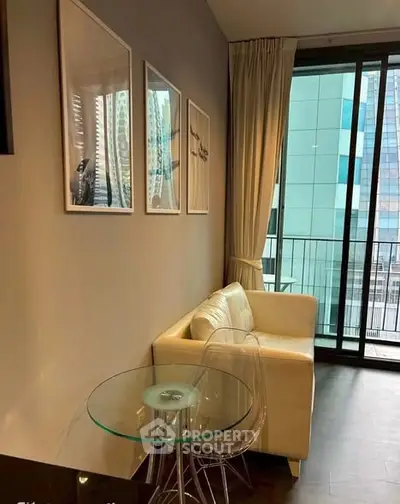 Modern living room with glass table and city view balcony in high-rise apartment.