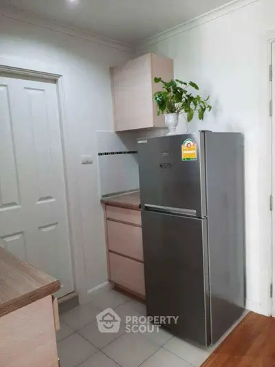 Modern kitchen corner with sleek fridge and stylish cabinetry