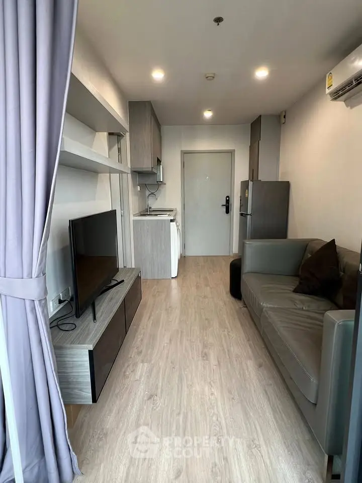 Modern living room with sleek furniture and open kitchen layout in a stylish apartment.