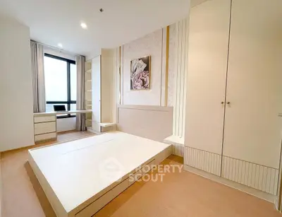 Spacious modern bedroom with built-in storage and large window view.