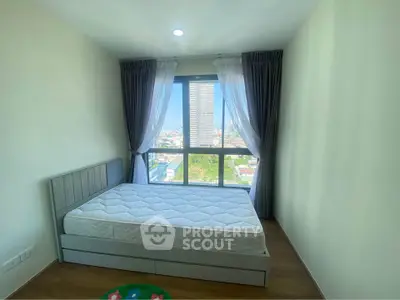 Bright bedroom with large window offering stunning city view, featuring a comfortable bed and elegant curtains.