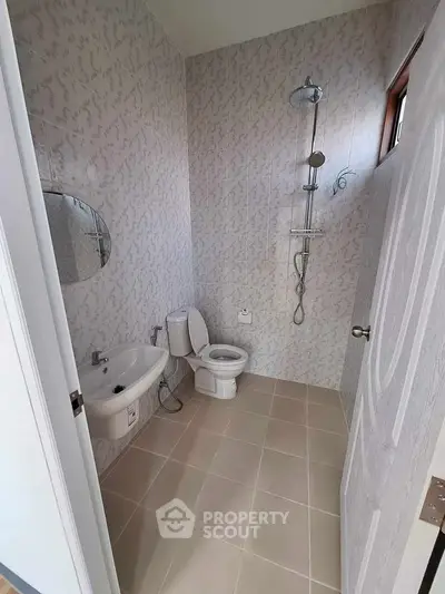 Modern bathroom with shower, toilet, and sink in a minimalist design.