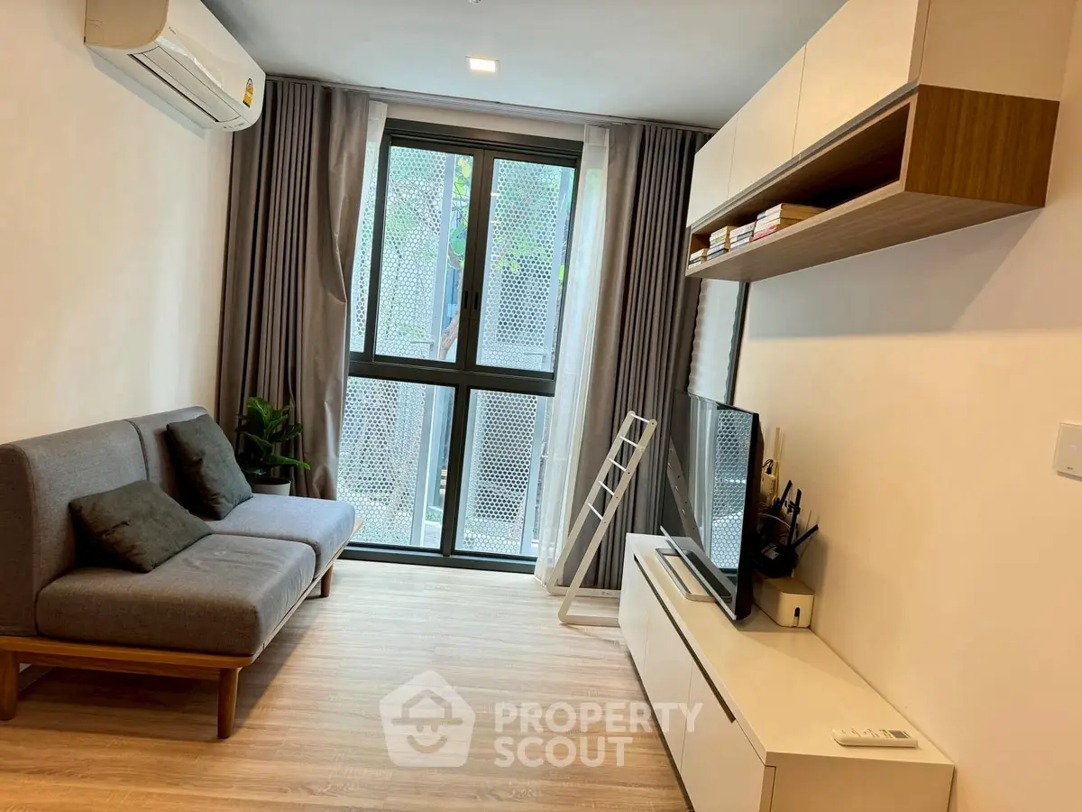 Modern living room with sleek furniture and large window for natural light.