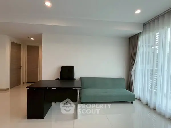 Modern living room with sleek desk and sofa, featuring large windows and elegant curtains.