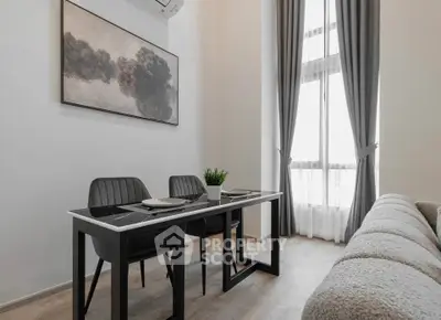 Modern living room with elegant dining area and large window, featuring stylish decor and natural light.
