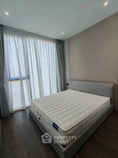 Modern bedroom with large window and stylish bed in a contemporary apartment.