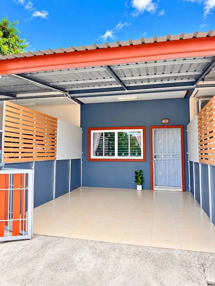 Charming modern home exterior with covered carport and vibrant blue facade.