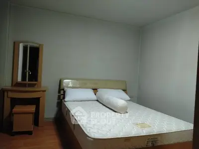 Cozy bedroom with a comfortable bed and wooden furniture, perfect for relaxation.