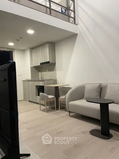 Modern loft apartment with stylish kitchen and cozy living area, featuring sleek furniture and open layout.