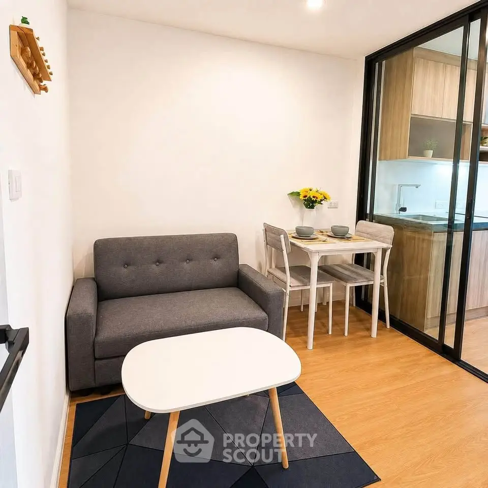 Cozy living room with modern furniture and open kitchen layout, perfect for urban living.
