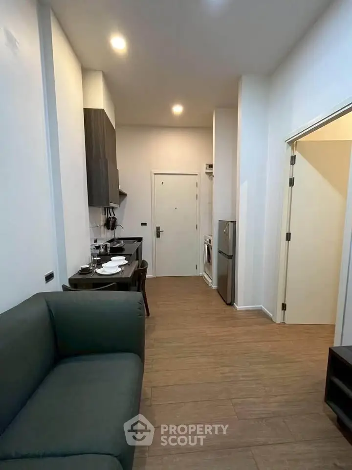 Modern apartment interior with open kitchen and cozy living area, featuring sleek design and efficient layout.