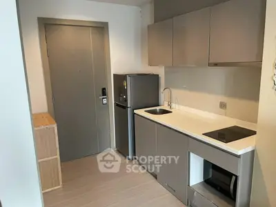Modern compact kitchen with sleek cabinetry and built-in appliances in a stylish apartment.