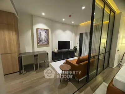 Modern living room with stylish decor and glass partition, featuring a cozy seating area and elegant lighting.