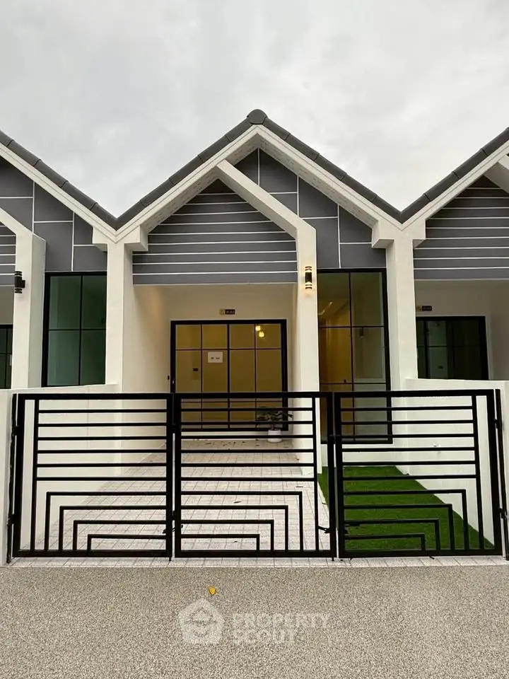 Modern townhouse exterior with sleek design and gated entrance, perfect for contemporary living.
