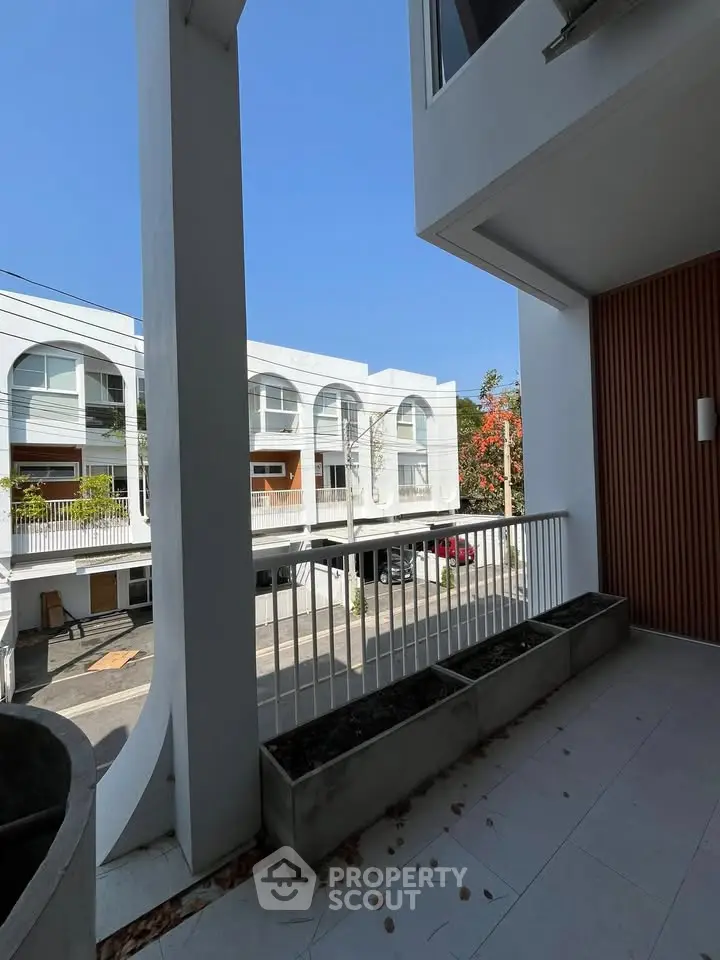 Modern balcony with sleek design and street view in contemporary building.